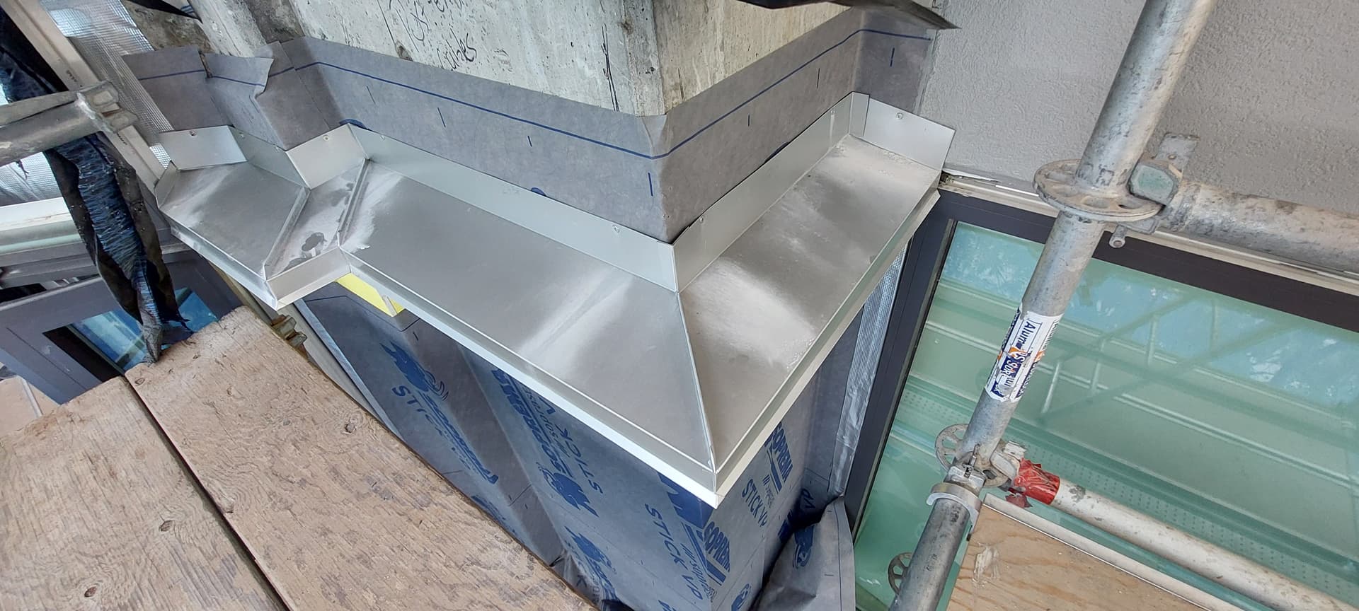 Custom roof-to-wall metal flashing transition by Tomron Construction in Maple Ridge, BC